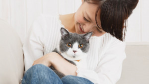 closeup of woman cuddling a gray and white cat