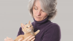 Woman holding orange kitten