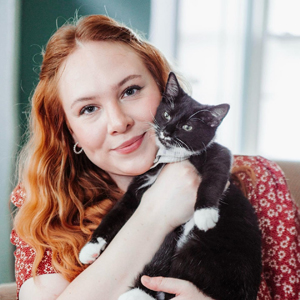 close up portrait of Emilie Rackovan holding a black and white cat